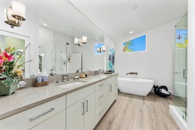 bathroom featuring wood-type flooring, vaulted ceiling, vanity, and plus walk in shower