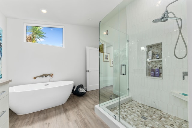 bathroom with hardwood / wood-style floors and separate shower and tub