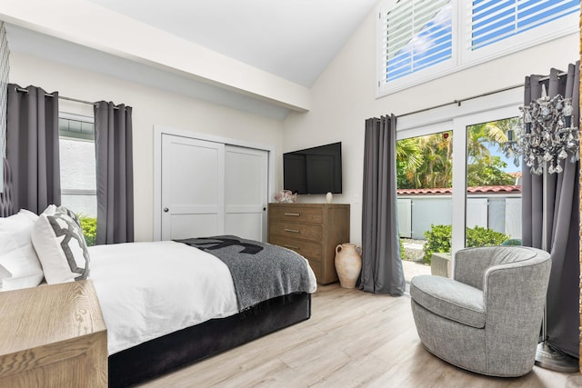 bedroom with multiple windows, light wood-type flooring, and high vaulted ceiling