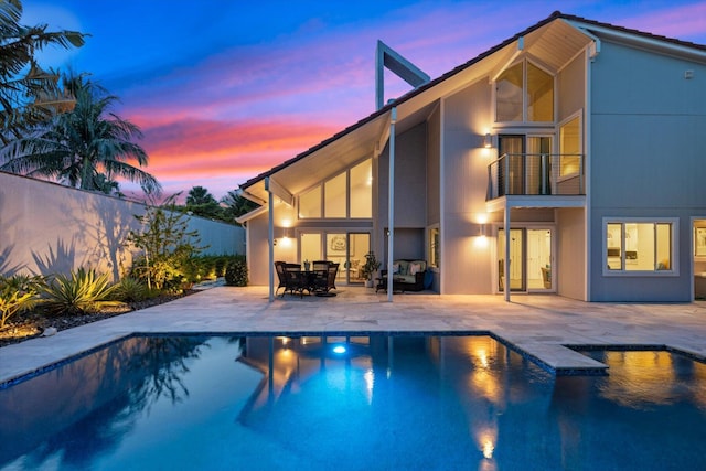 pool at dusk featuring a patio