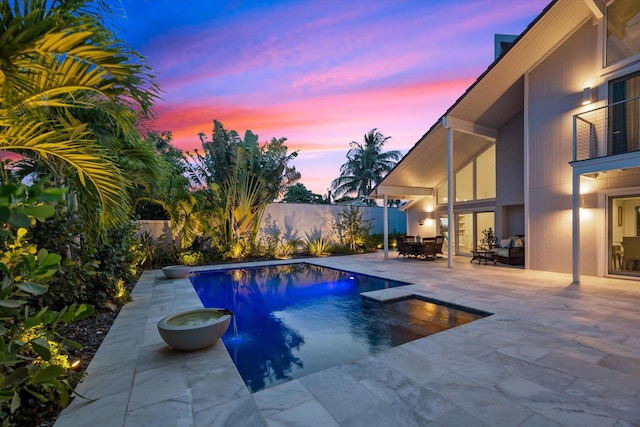 pool at dusk with a patio