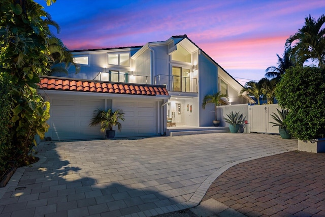 view of front of property featuring a balcony and a garage