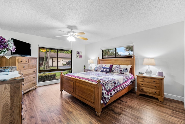 bedroom featuring dark wood-type flooring, a textured ceiling, and ceiling fan