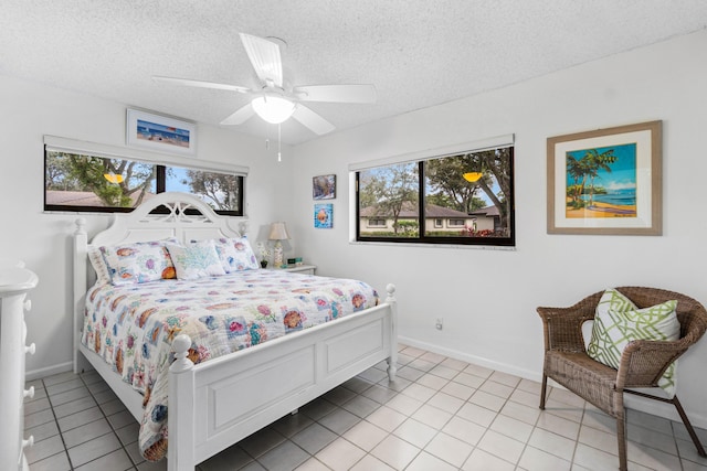 tiled bedroom featuring ceiling fan and a textured ceiling