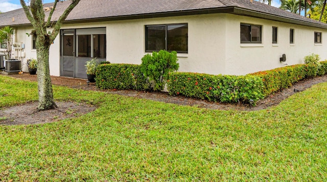 view of property exterior featuring central AC unit and a yard