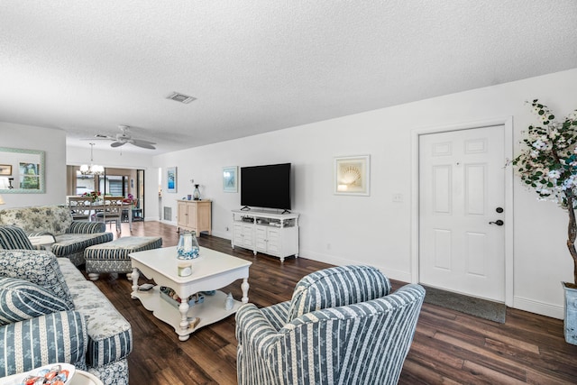 living room featuring ceiling fan with notable chandelier, a textured ceiling, and dark hardwood / wood-style flooring