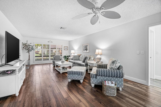 living room with ceiling fan, dark wood-type flooring, and a textured ceiling