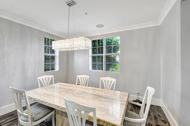 dining space featuring dark wood-type flooring, ornamental molding, and an inviting chandelier