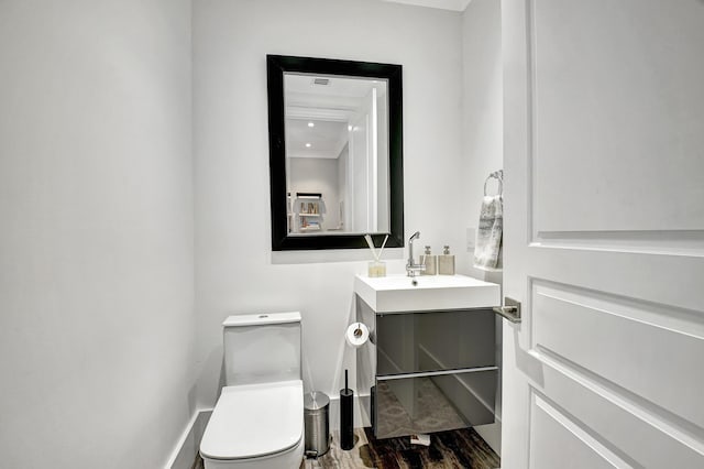 bathroom with wood-type flooring, toilet, and vanity