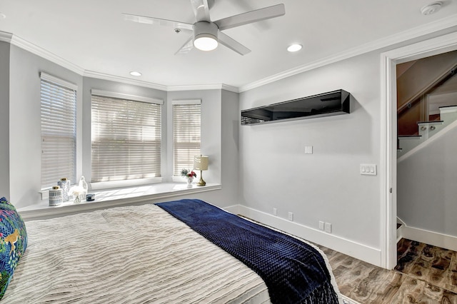 bedroom featuring ceiling fan, hardwood / wood-style floors, crown molding, and multiple windows