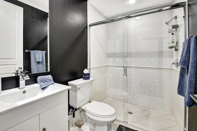 bathroom with a shower with door, toilet, tile patterned floors, and vanity