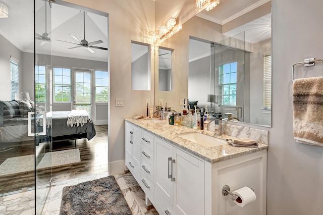 bathroom featuring ornamental molding, a shower with door, ceiling fan, and vanity