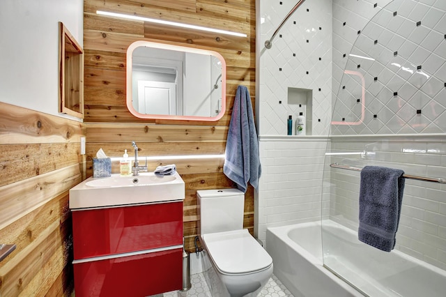 full bathroom with bathtub / shower combination, toilet, vanity, and wooden walls