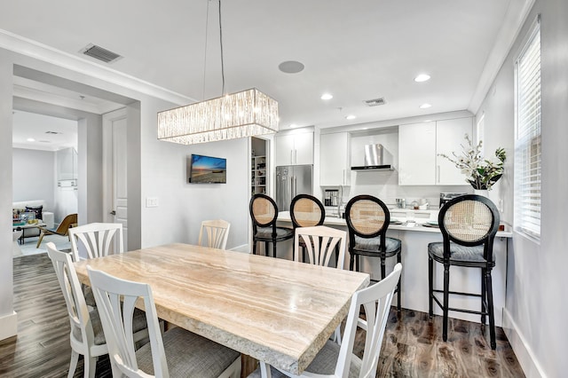 dining space featuring dark hardwood / wood-style flooring and ornamental molding