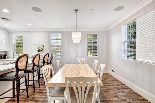 dining room with ornamental molding, plenty of natural light, and dark hardwood / wood-style flooring