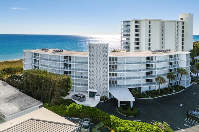 view of building exterior with a water view and a view of the beach