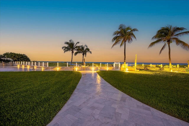 view of home's community with a water view and a yard