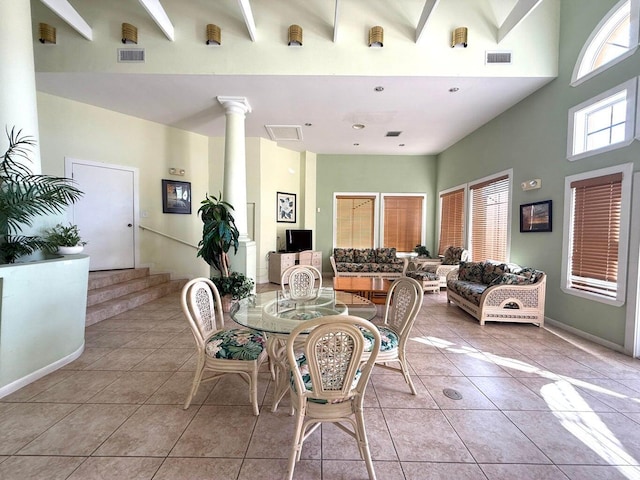 dining area with a high ceiling, ornate columns, beamed ceiling, and light tile patterned flooring