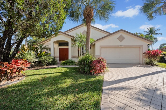 mediterranean / spanish-style home featuring a garage and a front lawn