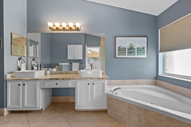 bathroom featuring a relaxing tiled tub, tile patterned floors, and vanity