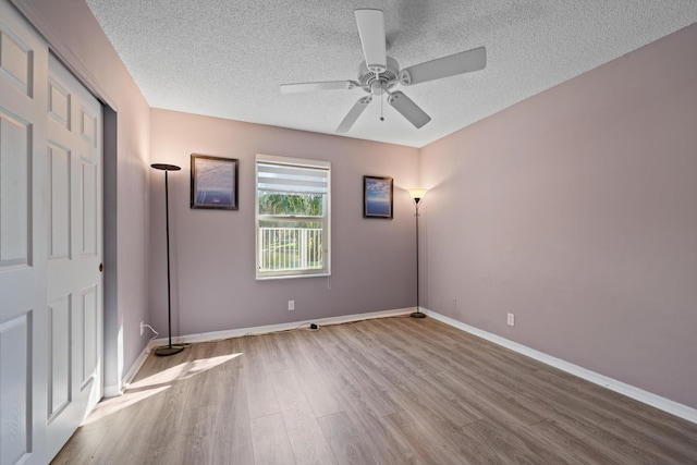 spare room featuring ceiling fan, a textured ceiling, and light wood-type flooring