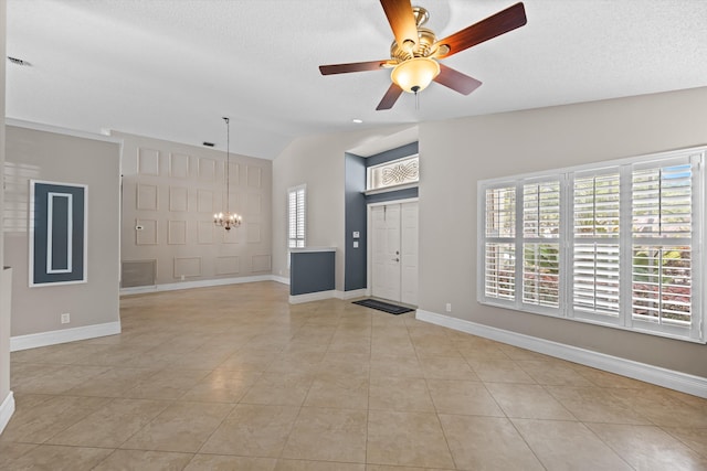 interior space featuring vaulted ceiling, a healthy amount of sunlight, light tile patterned floors, and a textured ceiling