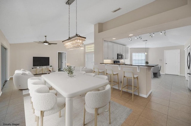 tiled dining room featuring rail lighting and ceiling fan