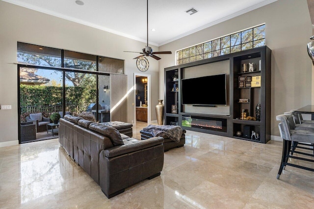 living room with a towering ceiling, a wealth of natural light, ornamental molding, and ceiling fan