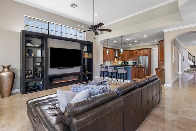 living room with ornamental molding and ceiling fan