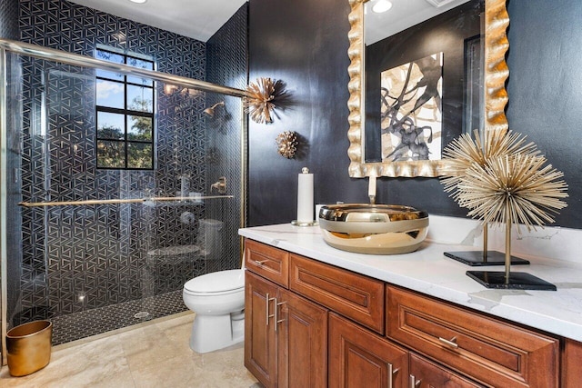 bathroom featuring tile patterned floors, vanity, toilet, and a shower with shower door