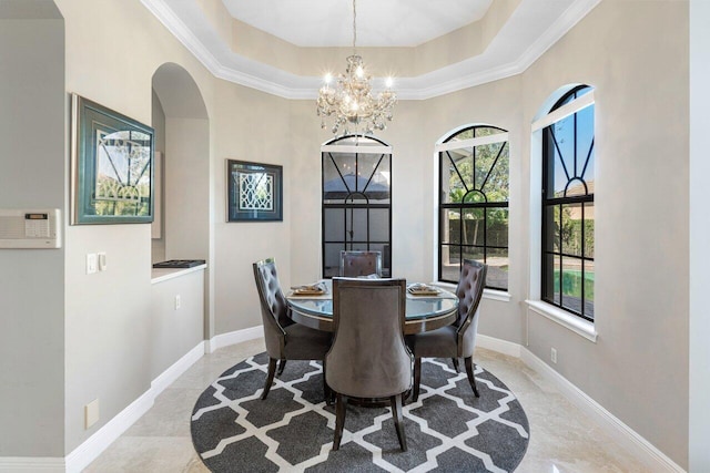 dining area featuring crown molding, a notable chandelier, and a tray ceiling