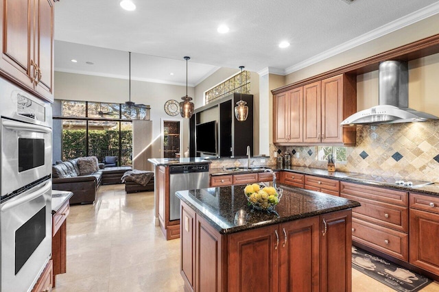 kitchen featuring sink, stainless steel appliances, a kitchen island, decorative backsplash, and wall chimney exhaust hood