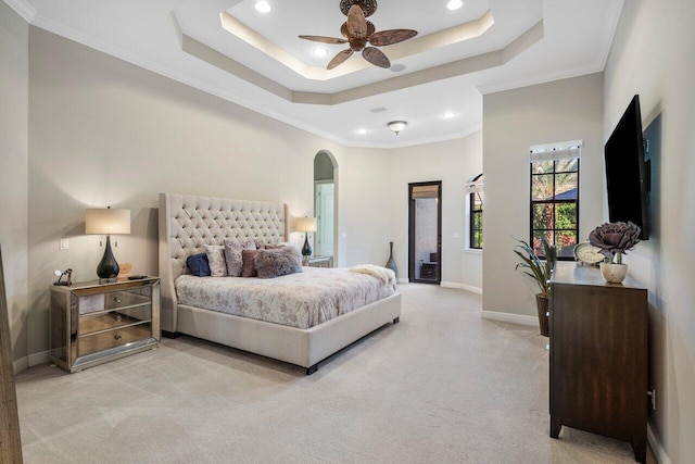 carpeted bedroom featuring ceiling fan, ornamental molding, and a raised ceiling