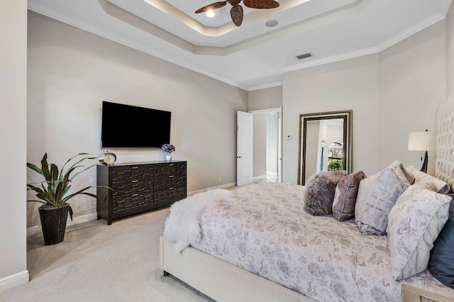 carpeted bedroom featuring ornamental molding, ceiling fan, and a tray ceiling