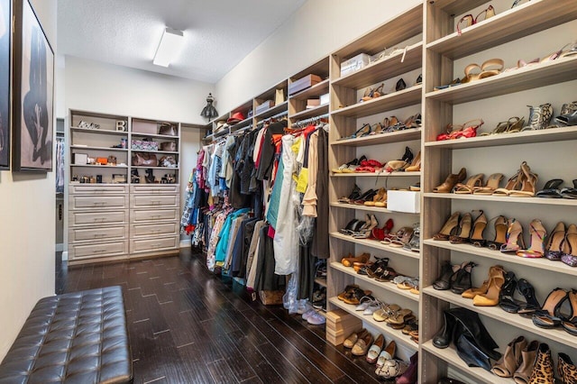 spacious closet with dark hardwood / wood-style flooring