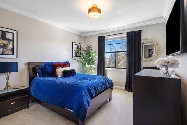 bedroom with crown molding and light colored carpet