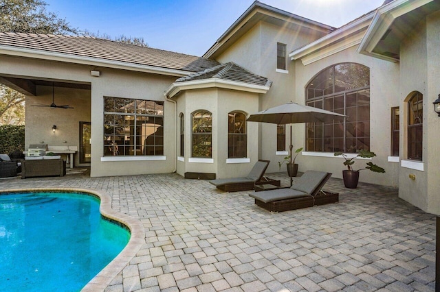 rear view of property featuring outdoor lounge area, ceiling fan, and a patio area