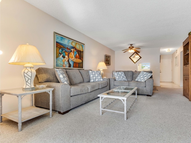 carpeted living room with ceiling fan and a textured ceiling