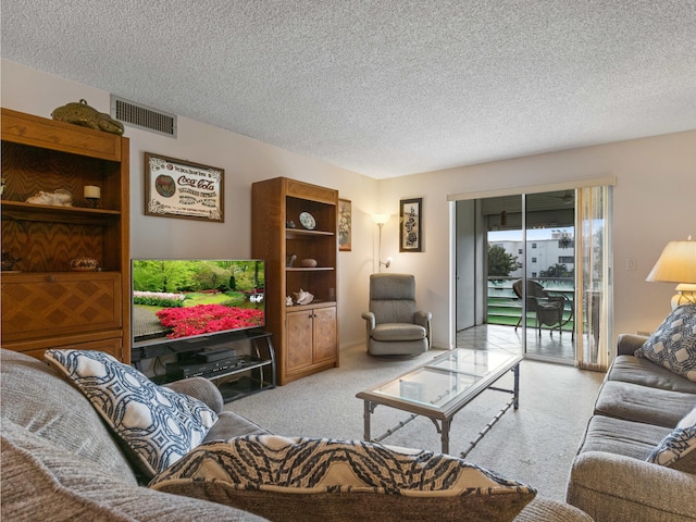 carpeted living room featuring a textured ceiling