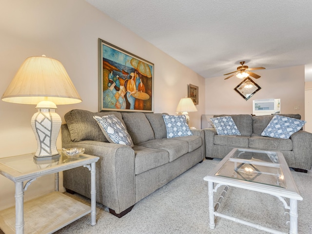 carpeted living room with ceiling fan and a textured ceiling