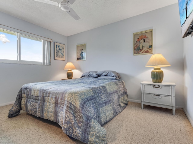 carpeted bedroom featuring ceiling fan and a textured ceiling