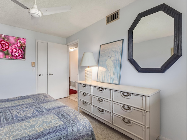 carpeted bedroom with a textured ceiling and ceiling fan