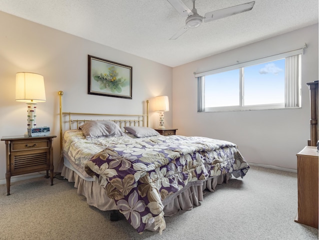 carpeted bedroom featuring a textured ceiling and ceiling fan