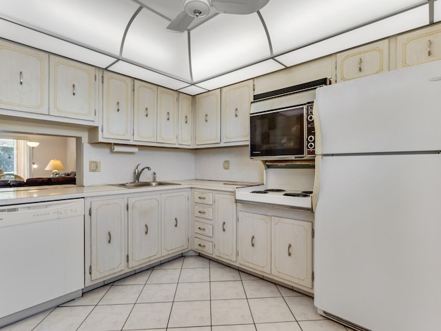 kitchen with sink, white appliances, light tile patterned floors, ceiling fan, and cream cabinetry