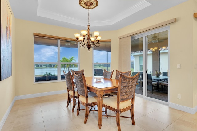 tiled dining area featuring crown molding, an inviting chandelier, a wealth of natural light, and a tray ceiling