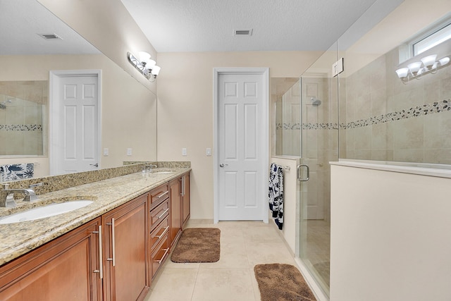 bathroom featuring a shower with shower door, a textured ceiling, tile patterned floors, and vanity