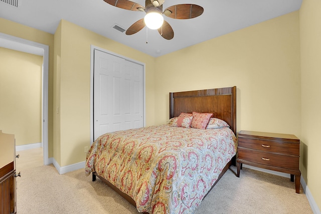 carpeted bedroom featuring ceiling fan and a closet