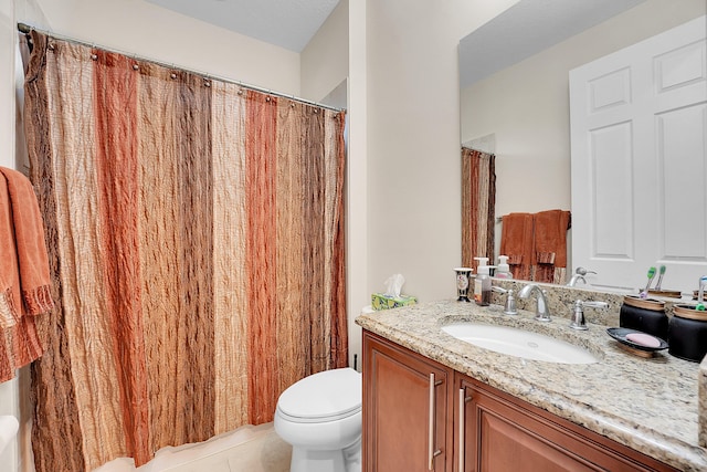 bathroom with toilet, vanity, and tile patterned flooring