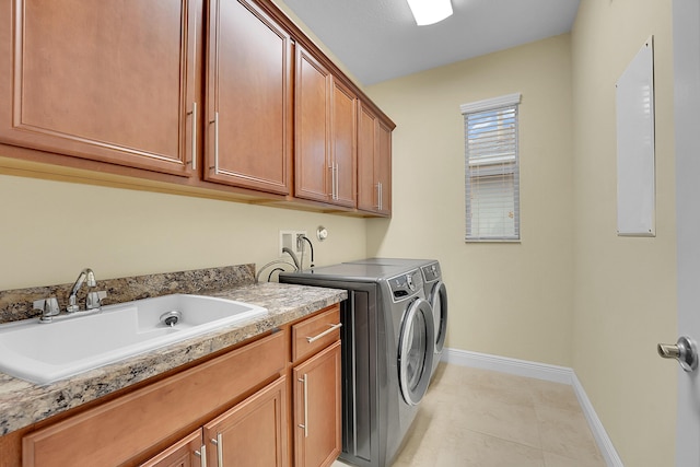 clothes washing area with cabinets, sink, washer and clothes dryer, and light tile patterned floors