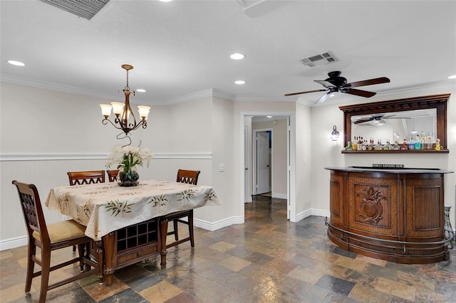 dining space with ceiling fan with notable chandelier, bar, and crown molding